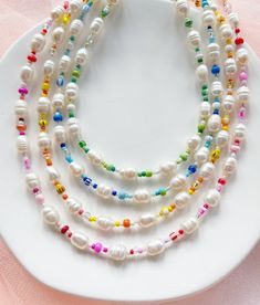 "Freshwater pearls are one of a kind and the coloured bead sequences may differ slightly so will not be exactly as shown in the photos but will be in this same style.  ∙ S I Z E ∙ G U I D E ∙ Standard length: 15\" + 2\" extension chain (17\" total length) - will sit roughly at or just above the collarbone for an adult.   M A T E R I A L S ∙    Durable steel cord, mixed glass beads, freshwater pearls, silver plated or sterling silver clasp and extension chain.  ∙ C A R E ∙  Avoid contact with water or hygiene and beauty products containing liquids, scents, or oils. Our jewellery is not suitable for young children due to the small and delicate beads used.    ∙ P A C K A G I N G ∙   The last photo shows the upgraded gift wrap option which includes a faux suede branded pouch, hand-painted wate Adjustable Multicolor Pearl Jewelry, Handmade Multicolor Pearl Necklace, Czech Glass Double Strand Necklaces With Colorful Beads, Double Strand Czech Glass Necklace With Colorful Beads, Pearl White Necklaces With Beaded Chain, White Necklace With Tiny Oval Beads, Pearl White Necklaces With Beaded Chain And Round Beads, Handmade Rainbow Pearl Jewelry, Adjustable Pearl White Beaded Necklaces