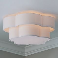 a circular light fixture in a room with white walls and ceiling lights on either side