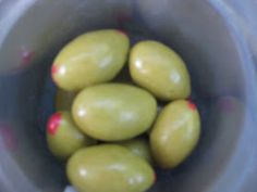 some green olives in a plastic container