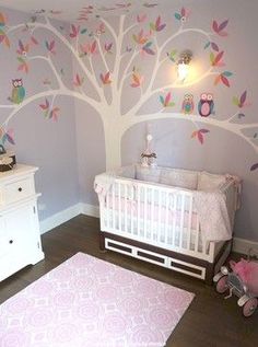 a baby's room with a tree painted on the wall