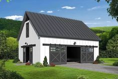 a large white barn with a black roof and two garage doors on the side of it