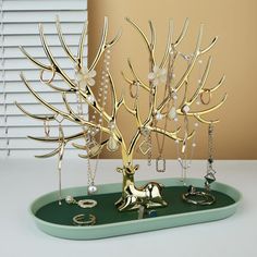 a gold tree with pearls and rings on a tray