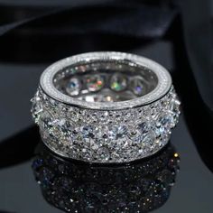 a diamond ring sitting on top of a black surface