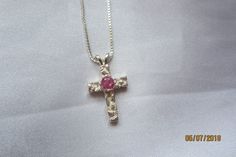 This pendant hold one petite free form cross with a round pink cubic zirconia accent stone.  The cross and 18 inch chain are both Sterling Silver.  A perfect gift for a young lady on her birthday, confirmation or any other significant event in her life. Pink Sterling Silver Cross Jewelry, Pink Cross Sterling Silver Jewelry, Pink Sterling Silver Birthstone Necklace, Pink Cross Pendant Jewelry As Gift, Pink Cross Pendant Necklace For Gift, Pink Cross Necklace For Gift, Pink Cross Necklace For Gifts, Pink Cross-shaped Jewelry For Gift, Pink Cross-shaped Jewelry Gift