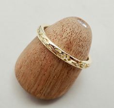 a gold ring sitting on top of a wooden object