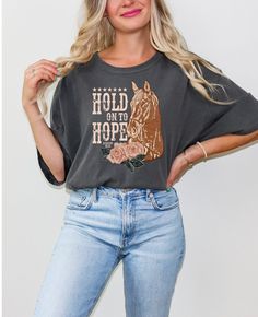 Hold On To Hope Christian Faith Based T-shirt with beautiful western font and brown horse for all Women and Teen Girls for all occasions.  Printed on the popular Comfort Colors tee.  Design by the fabulous Harper House 316 here on Etsy.  *shirt runs large, please double check size chart* Please Note colors may vary slightly due to screen lighting Comfort Colors introduces the "Comfort Colors 1717" garment-dyed t-shirt; a fully customizable tee made 100% with ring-spun cotton. The soft-washed, ga Short Sleeve Cotton Top With Horse Design, Cotton Short Sleeve Top With Horse Design, Casual Short Sleeve T-shirt With Horse Design, Casual Short-sleeved T-shirt With Horse Design, Casual Short Sleeve Tops With Horse Design, Hold On To Hope, Western Font, Tshirt For Women, Brown Horse