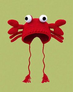 a red knitted crab hat with eyes and legs