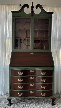 an antique dresser with glass doors and drawers