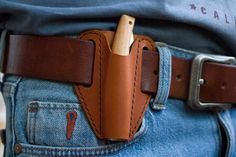 a leather belt with a wooden clip sticking out of it's back pocket in someones jeans