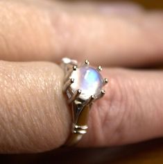 This is a stunning rainbow moonstone cabochon set in a minimalist sterling silver ring. The multitude of prongs help to protect the moonstone because it's a fairly soft gem. This moonstone is not completely clear of inclusions, but it is lovely! If you love rainbow moonstone, you will love this ring! The price is a steal, the ring is a favorite of ours, and the combination of moonstone and sterling silver is perfect!  This ring is part of our ColorSplash Minimalist line! The item pictured is the Moonstone Ring Sterling Silver, Love Rainbow, Rainbow Moonstone, Solitaire Ring, Moonstone, Sterling Silver Rings, Jewelry Rings, Silver Rings, Gems