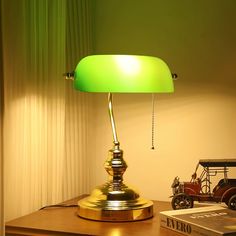 a green lamp sitting on top of a wooden desk