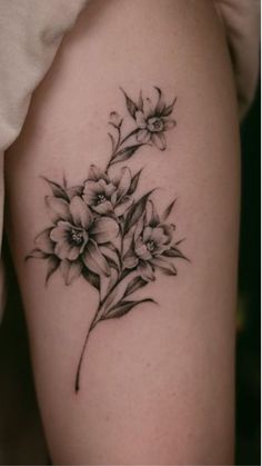 a black and white flower tattoo on the right thigh, with flowers growing out of it