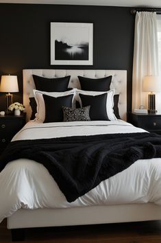 a bed with black and white comforter in a bedroom next to two lamps on either side of the bed