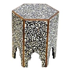 a black and white patterned table with two legs on each side, sitting against a white background