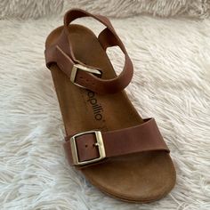 Birkenstock Papillio Soley Wedge Sandals Cognac Brown Nubuck Leather 36n Size 5-5.5 Nar-Med New In Box (Box Damaged) The Soley Is A Classic Wedge Heel Sandal From Papillio. The Soley Is The Perfect Combination Of Style And Comfort, With Its Simple Design And Sleek Heel Strap. The Upper Is Made From High-Quality, Soft Natural Leather. Polyurethane Footbed Upper: Natural Leather Footbed Lining: Suede Sole: Polyurethane (Pu) 2 1/2" Heel; 1" Platform Details: Two Straps, Each With An Individually Ad Casual Wedge Sandals With Heel Strap And Round Toe, Beach Wedge Sandals With Heel And Single Toe Strap, Beach Wedge Sandals With Heel And Toe Straps, Casual Closed Toe Wedge Sandals With Heel Loop, Brown Wedge Sandals With Cushioned Footbed And Flat Heel, Brown Flat Heel Wedge Sandals With Cushioned Footbed, Casual Adjustable Wedge Heel Footbed Sandals, Casual Leather Wedge Sandals With Low Heel, Casual Low Heel Wedge Sandals With Heel Strap