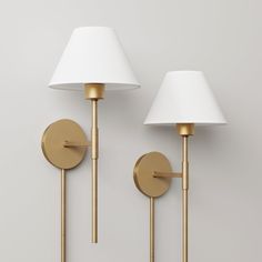 two lamps on the wall next to each other, one with a white lamp shade