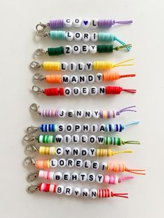 six key chains with words written on them in different colors and sizes, all lined up against a white background