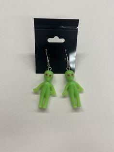 These little green men came from space to rest on your ears! These cute earrings are out of this world! Packing size is just a filler number as we don't have boxes currently! Green Handmade Fun Earrings, Adjustable Green Drop Plug Earrings, Green Novelty Dangle Jewelry, Green Dangle Novelty Jewelry, Fun Green Nickel-free Earrings, Green Fun Earrings For Gift, Green Fun Earrings For Gifts, Fun Green Earrings For Gifting, Fun Green Earrings For Gifts