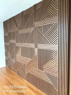 a wooden paneled wall with geometric designs on it and wood flooring in the background