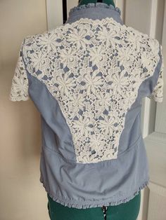 "Refashioned light blue jacket, lace, flowers - embellished with hand-embroidered flowers and lace on back and sleeves - 2 hook closure (pearl area) - removable button pin - size M, see measurements below - hand-wash One of a kind Shoulder to bottom of ruffle 21\" - see picture with measurements near 17\" under the arms 15\" across shoulders" Fitted Cotton Lace Top With Short Sleeves, Fitted Lace Top With Crochet Trim And Short Sleeves, Fitted Short Sleeve Lace Top, Fitted Short Sleeve Lace Top With Lace Work, Fitted Blue Lace Top With Lace Trim, Fitted Blue Tops With Lace Collar, Blue Lace Patchwork Top For Spring, Blue Fitted Top With Lace Collar, Fitted Cotton Lace Top With Lace Work