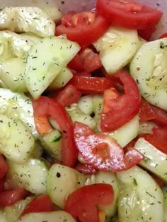 cucumber and tomato salad in a bowl with seasoning sprinkled on top