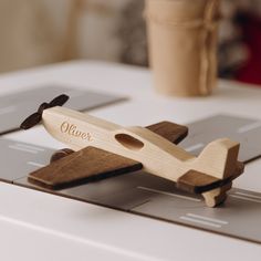 a wooden toy airplane sitting on top of a table