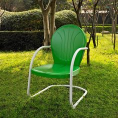 a green lawn chair sitting in the grass