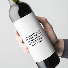 a hand holding a bottle of wine that says thanks for teaching my interactive little hot machine