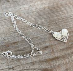 This gorgeous upcycled spoon heart necklace was made by marrying the ends of two silverplate spoon handles. The heart pendant was then adorned with a rhinestone flower for a little pizazz. Rhinestone flower is from a vintage rhinestone earring. The chain is a lovely loop chain in a silverplate finish. We do not cast/mold any of our designs, they are all handmade, one-of-a-kind creations. Manufacturer: William Rogers Pattern: Hiawatha Year: 1939Size/Dimensions: Pendant is ~1"w x ~1". Chain is ~22 Vintage Charm Heart Pendant Jewelry For Anniversary, Vintage Charm Pendant Jewelry For Anniversary Gift, Vintage Heart Pendant Necklace For Anniversary, Heart Pendant Necklace With Vintage Charm For Anniversary, Vintage Pendant Jewelry For Anniversary Gift, Anniversary Gift Pendant Jewelry With Vintage Charm, Anniversary Heart Pendant Necklace With Vintage Charm, Vintage Charm Heart Pendant Necklace For Anniversary, One Of A Kind Heart Jewelry For Anniversary