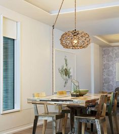 a dining room table with chairs and a light fixture hanging from it's ceiling