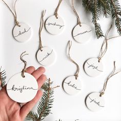 a hand holding a white ornament with writing on it