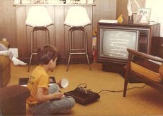 a young boy sitting on the floor in front of a tv