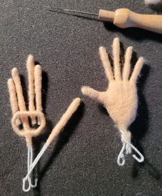 two hand puppets made out of yarn with scissors on the ground next to them,