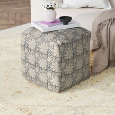 a living room with a white couch and a coffee table on top of a rug