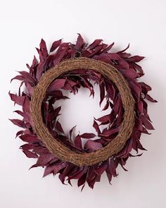 a wreath with purple leaves hanging on the wall