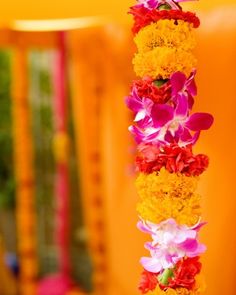 an arrangement of flowers is hanging from a pole in the middle of a decorated area