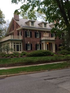 a large brick house sitting on the side of a road