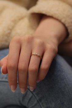 a woman's hand with a diamond ring on her left wrist, sitting down