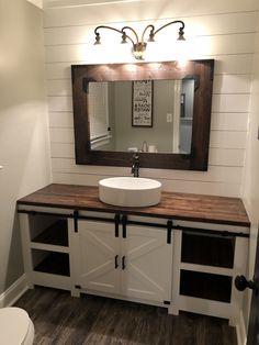 a bathroom with a sink, mirror and wooden counter top in the middle of it