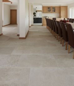 a long dining table with brown chairs in a large room