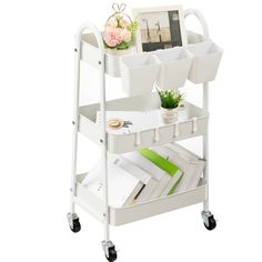 a white cart with books, magazines and a clock on it's wheels is shown