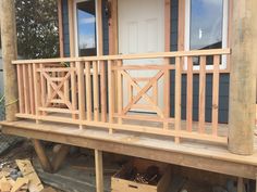 a wooden porch with steps leading up to the front door and windows on each side