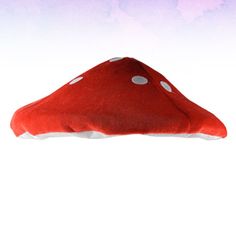 a red mushroom pillow with white polka dots on it's side, sitting in front of a white background