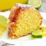 a close up of a piece of cake on a plate with lemons and limes