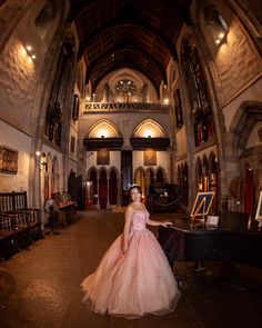 a woman in a pink dress standing next to a piano