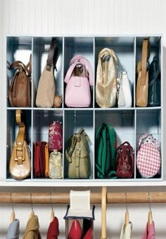 a bunch of purses are lined up in a storage unit with the doors open