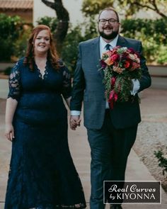 a man and woman walking down a sidewalk holding hands