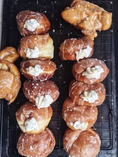 a bunch of doughnuts that are sitting on a cooling rack with icing