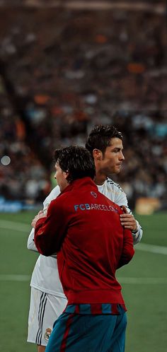 two soccer players hugging each other on the field