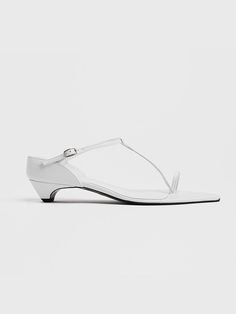 pieton is a modern-based shoe brand developed by imagining women in the city, and presents items that are not limited to seasons through slick shapes, minimal designs, and variations of various materials.- This is a toe-ring sandal- A T-strap that highlights the instep line- Very low height, with only the heel slightly hidden and the entire foot exposed- The low heel height allows for a stable fit Modern T-strap Sandals For Spring, Modern White Sandals With Heel Loop, Modern White Sandals With Low Heel, Sleek White Leather Sandals, Modern T-strap Heels For Summer, Modern White Ankle Strap Sandals, Modern White Sandals With Single Toe Strap, Modern White Pointed Toe Sandals, White Sandals With Sculpted Heel And Single Toe Strap